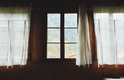 wooden wall with window and white curtain